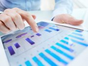 Datenmarktplatz BitsaboutMe expandiert nach Deutschland User analysiert Daten auf Tablet.